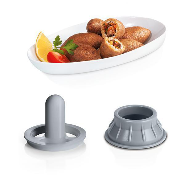 Ein Teller mit Kibbeh und zwei grauen Formen zu ihrer Herstellung.