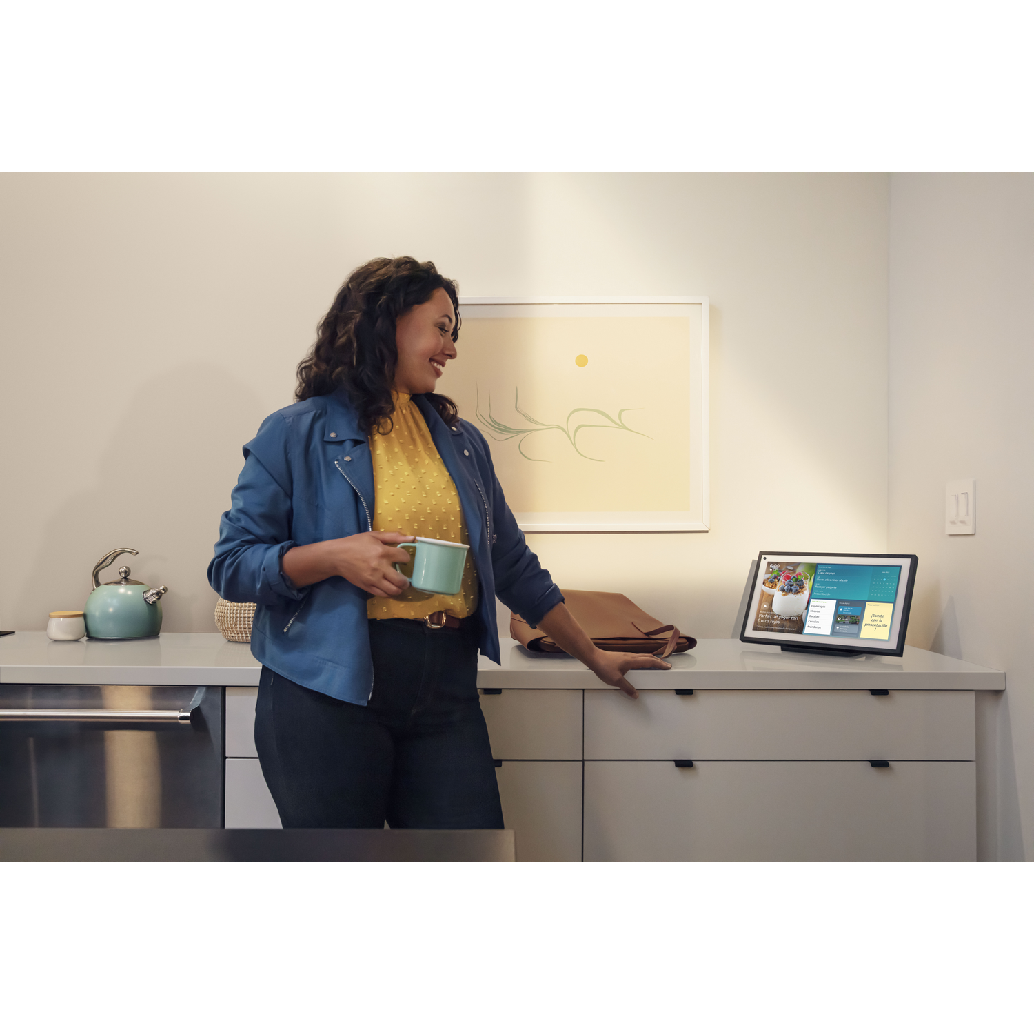 Una mujer con una taza mirando una pantalla inteligente en una cocina.