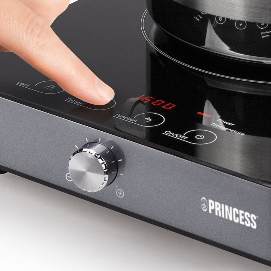 Een close-up van een vinger die op de 'Timer'-knop van een Princess inductiekookplaat drukt.