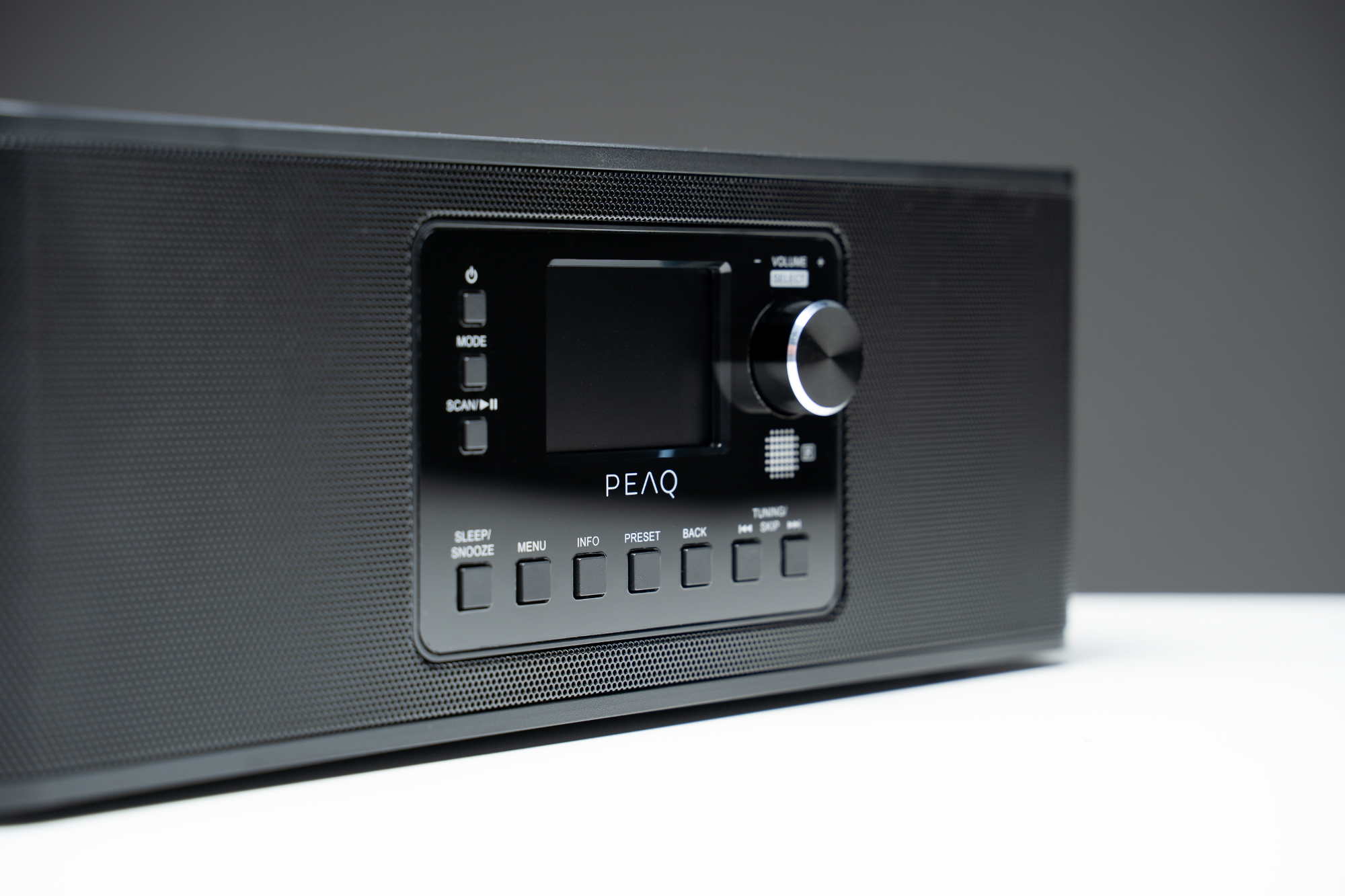 Système audio PEAQ noir avec écran et boutons. Le bouton de volume est à droite.
