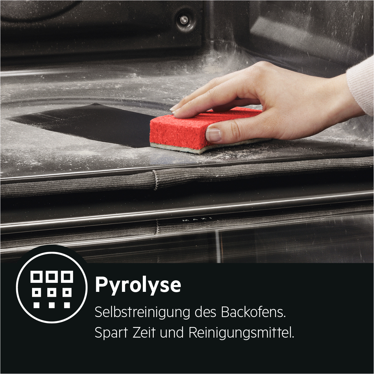 Eine Hand reinigt einen Ofen mit einem roten Schwamm. Weißer Staub ist sichtbar.