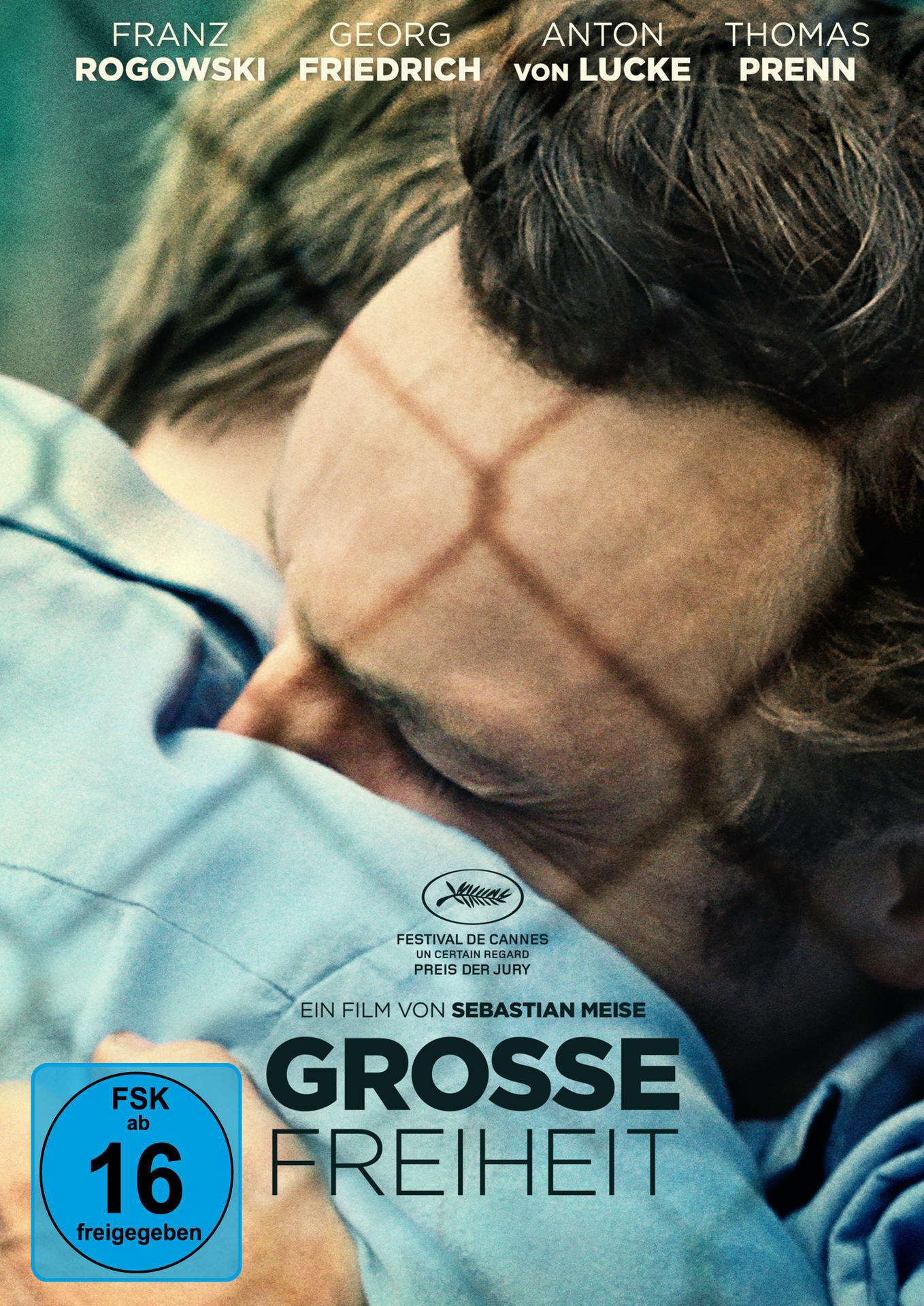Filmposter von 'Grosse Freiheit'. Nahaufnahme eines Mannes hinter Gittern.