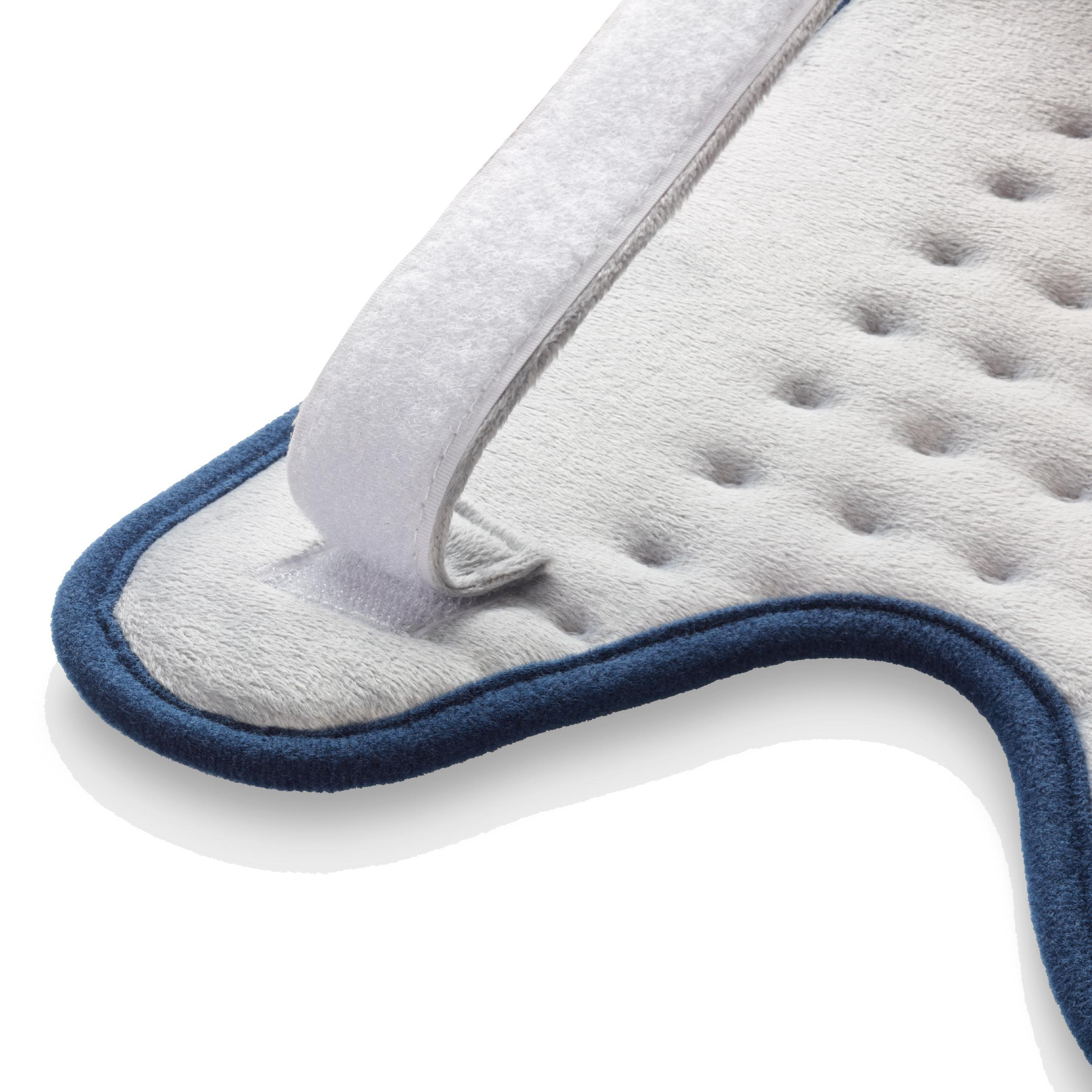 Ein weißes und blaues Heizkissen mit Klettverschluss. Es hat Mulden und einen blauen Rand.