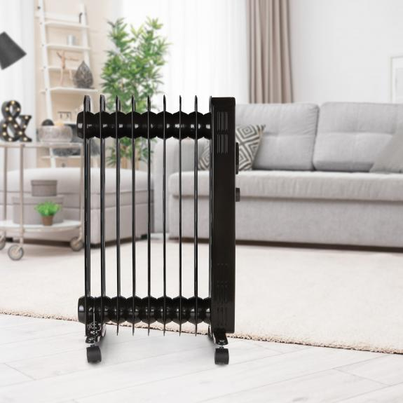 Black electric radiator in a living room. A couch, rug, and other home decor are visible.