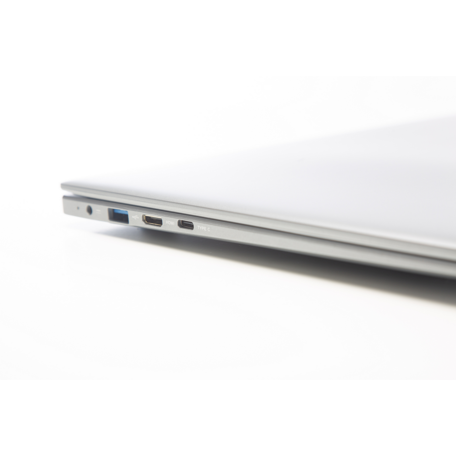 Un primer plano del lateral de una laptop con puertos: USB, HDMI y USB-C. La laptop es de color plateado.