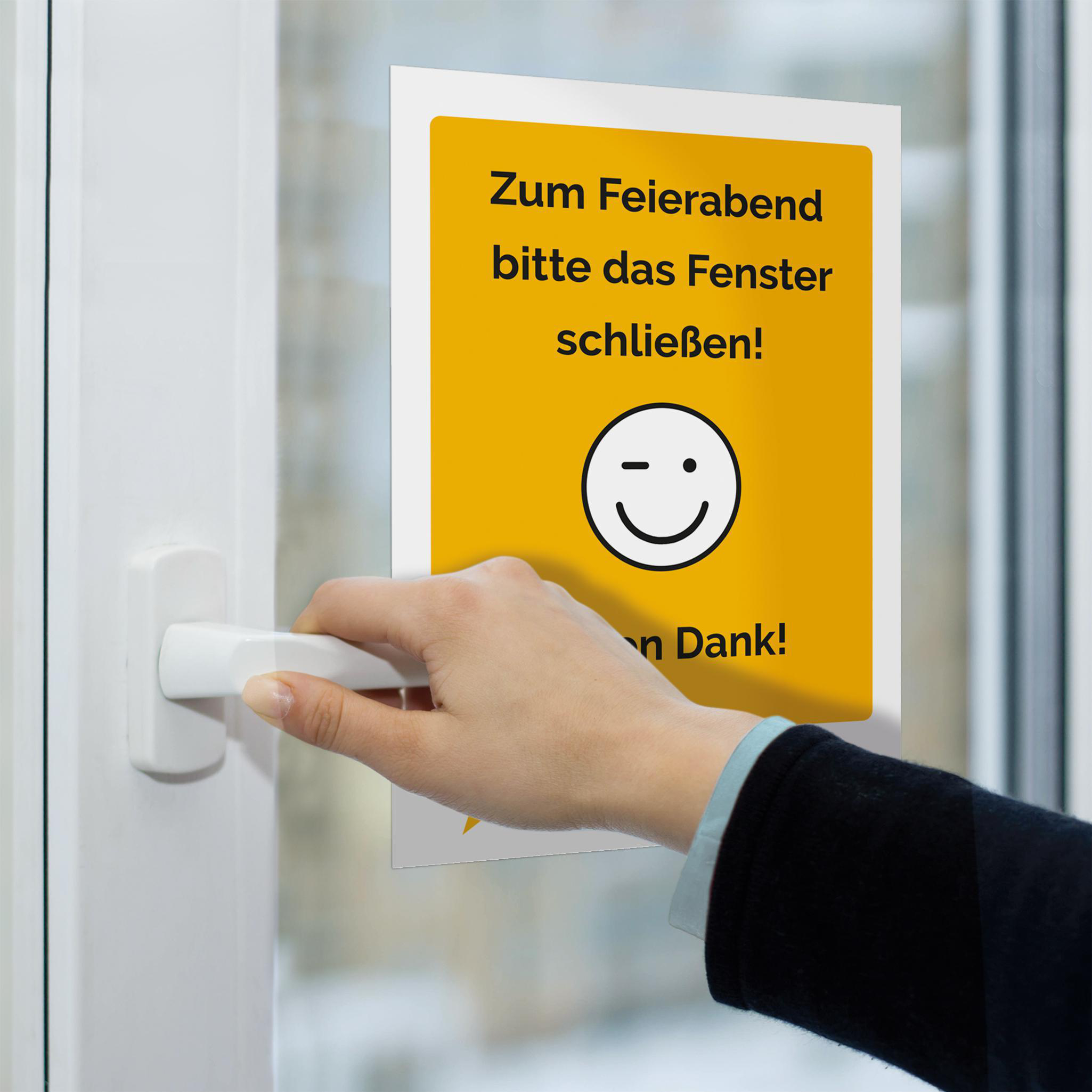 Eine Hand öffnet ein weißes Fenster, ein Schild sagt: Fenster schließen! Vielen Dank!