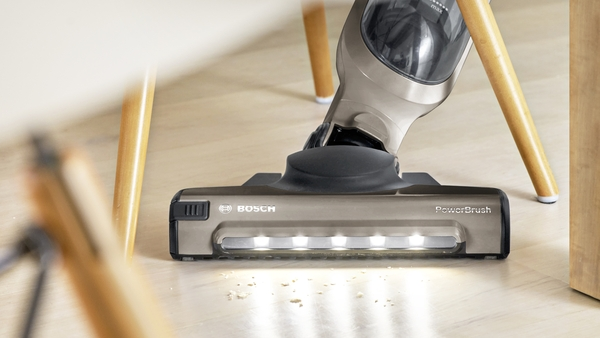 Porszívófej fa padlón. Bosch PowerBrush logó. Homályos háttér.