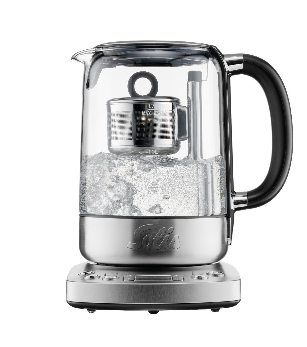 Bouilloire électrique en verre avec infuseur à thé. Eau bouillante à l'intérieur. Base argentée et poignée noire.