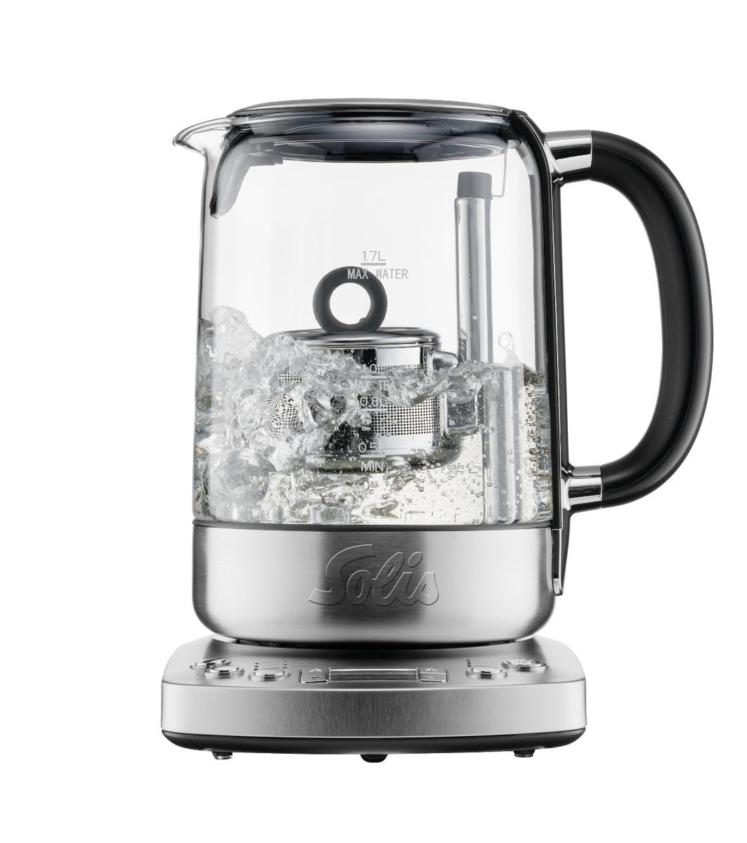 Bouilloire en verre avec glace, anse noire, sur base argentée.