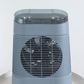 Egy kicsi, kék, hengeres fűtőtest ventilátorral és vezérlőpanellel.