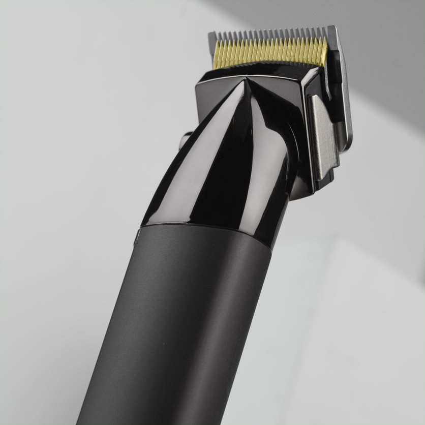 Black hair clipper with shiny finish, close-up view of the blade and handle.