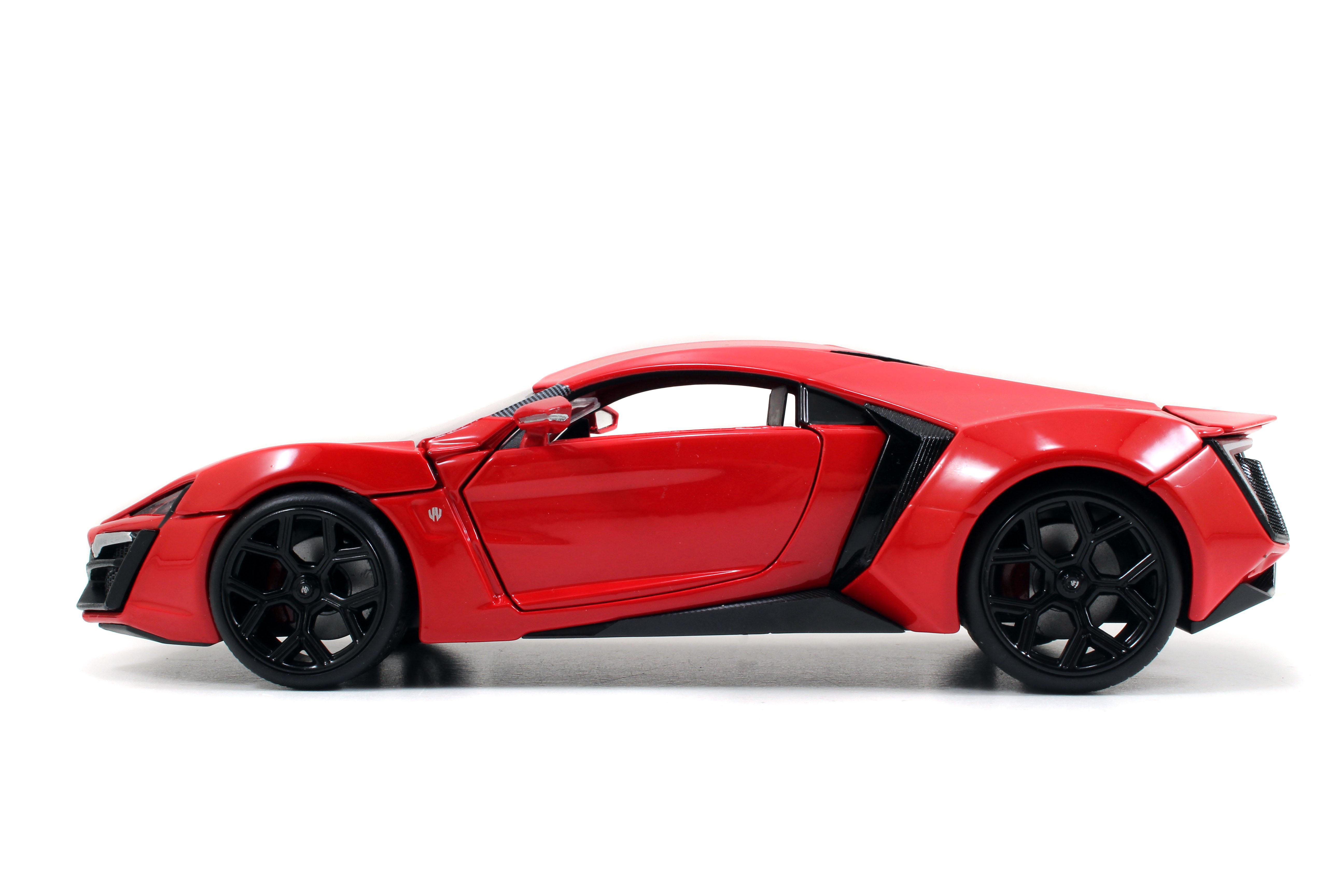 Ein rotes Spielzeugauto von der Seite. Es hat schwarze Räder und eine glänzende Oberfläche auf weißem Hintergrund.