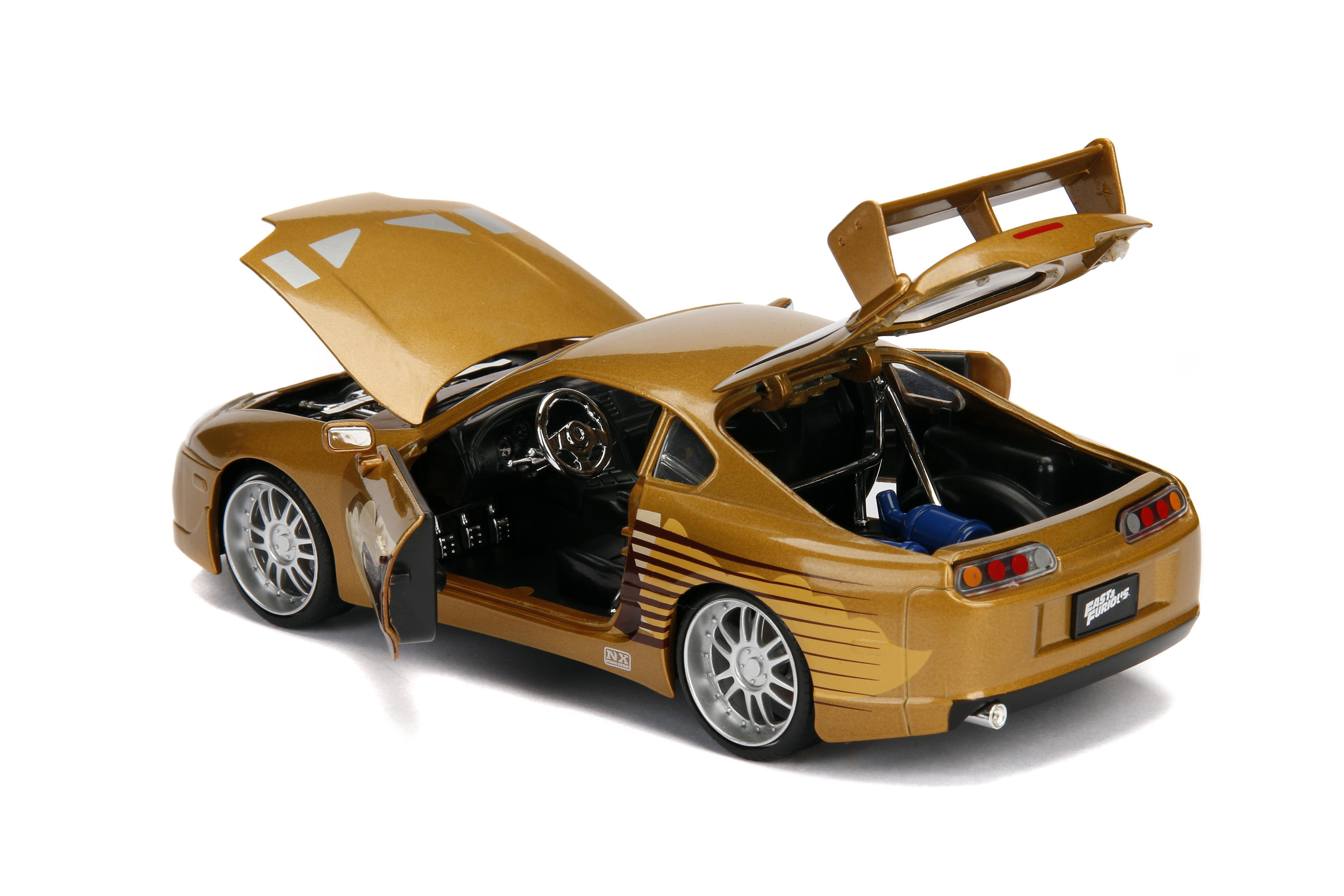 Goldenes Spielzeugauto mit geöffneter Motorhaube und Türen. Enthält einen Spoiler und das Fast & Furious-Logo. Weißer Hintergrund.