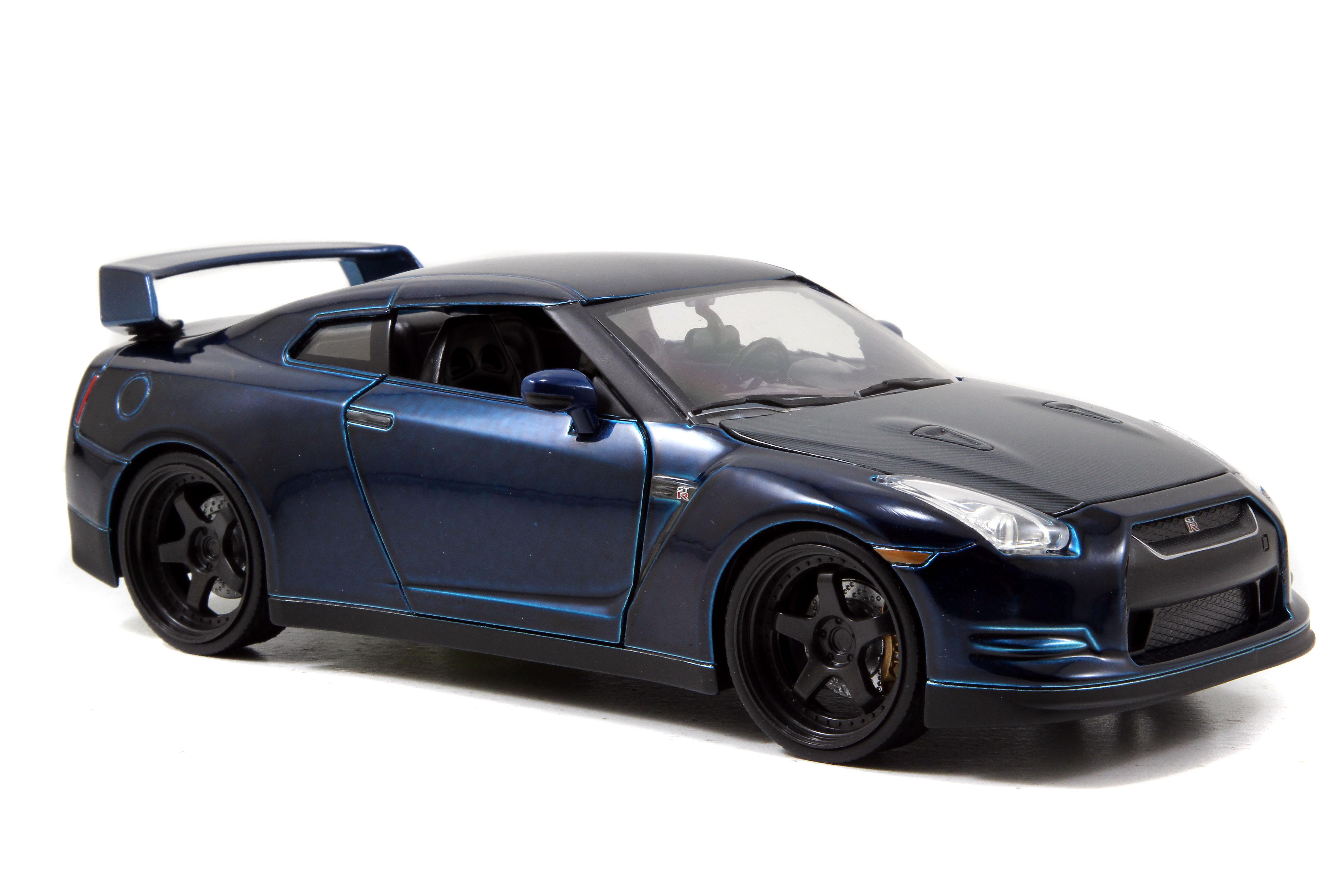 Ein blaues Sportauto auf weißem Grund. Das Auto hat schwarze Räder und einen Heckspoiler. Der Hintergrund ist weiß.