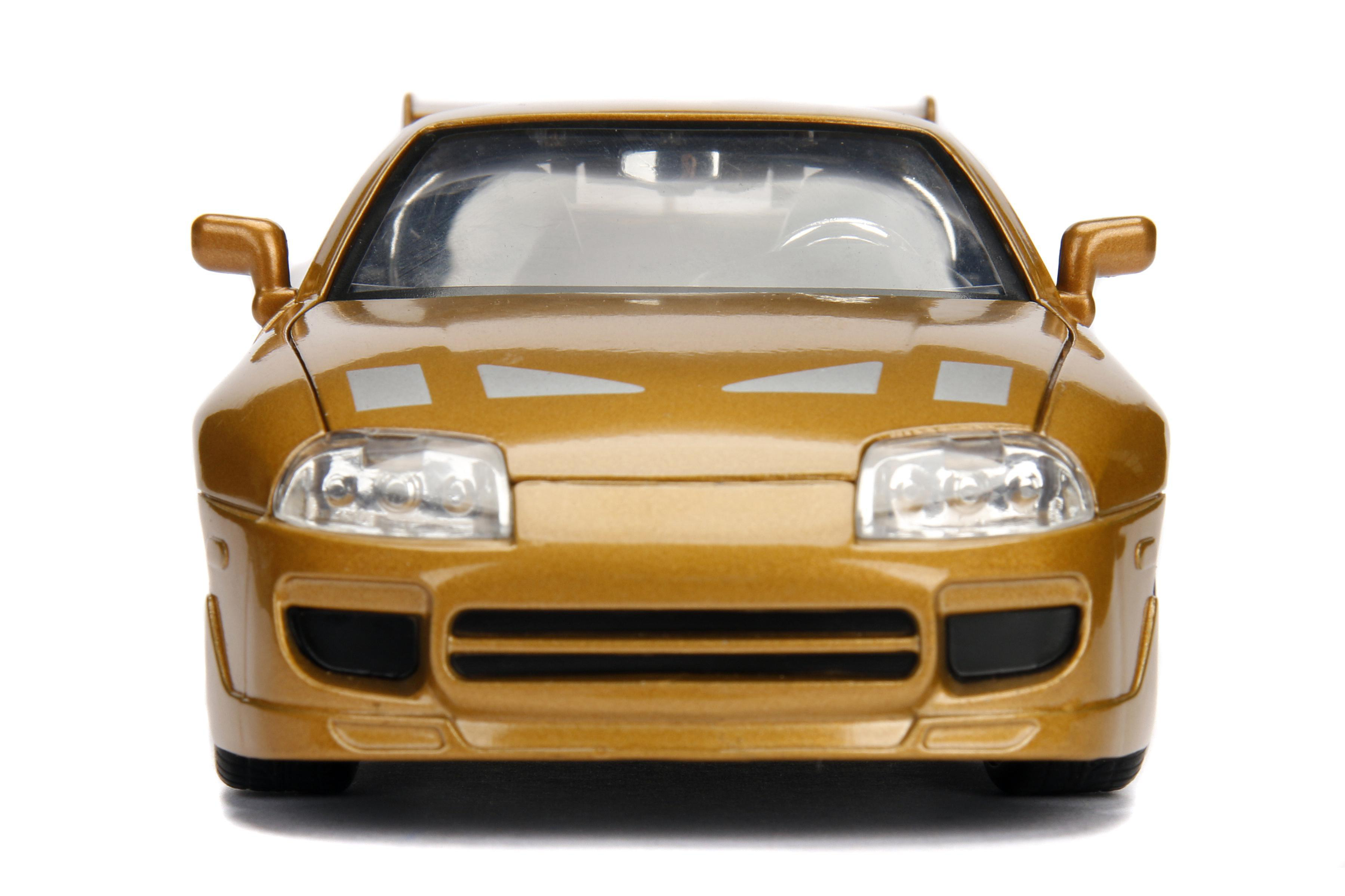 Ein goldenes Spielzeugauto ist zentriert und blickt nach vorne. Scheinwerfer und ein Spoiler sind sichtbar. Der Hintergrund ist weiß.