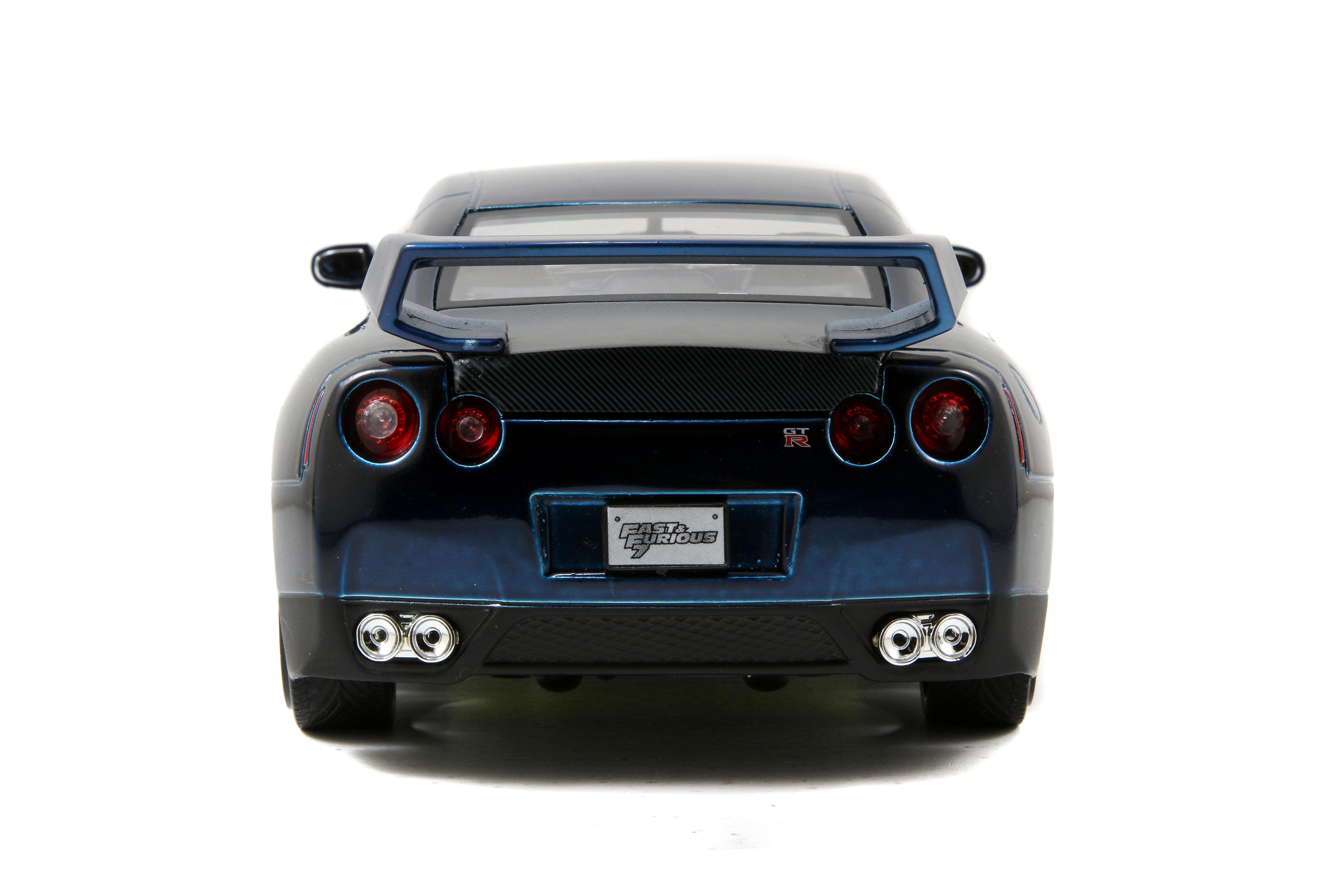 Rückansicht eines blauen Spielzeugautos. Es hat rote Rücklichter, Doppelauspuffrohre und ein Fast & Furious-Logo.