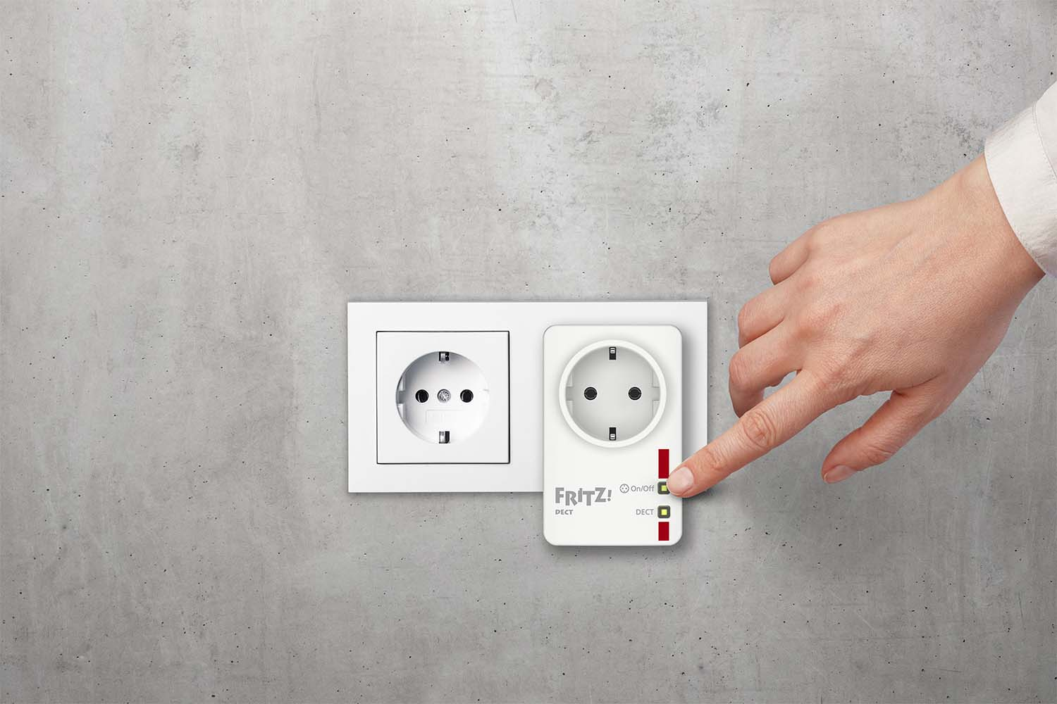Una mano presiona un botón en un adaptador de línea eléctrica blanco enchufado a una toma de corriente.