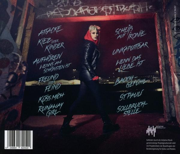 Albumcover mit einer Frau in Lederjacke und Songtiteln. Graffiti-Wandhintergrund.