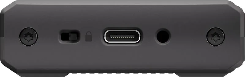 Primo piano di un dispositivo grigio scuro. Include viti, un interruttore, un simbolo di blocco, una porta USB-C e un jack per cuffie.