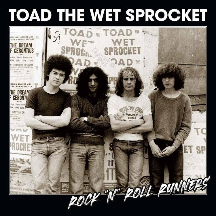 Vier mannen van Toad the Wet Sprocket, armen over elkaar, staand voor posters.