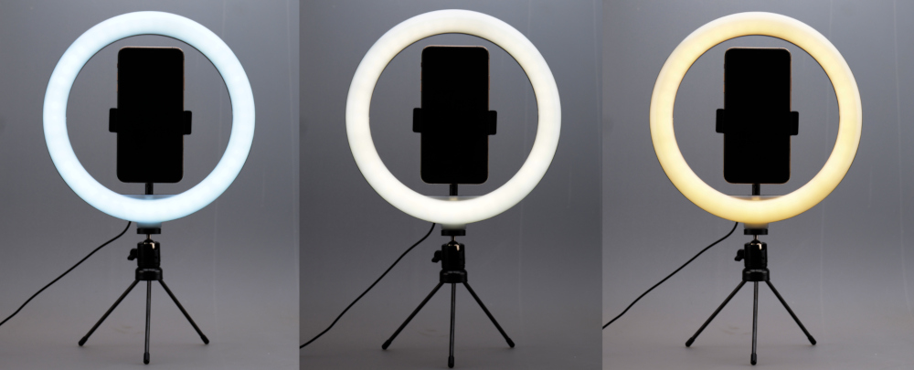 Three ring lights on tripods. Varying color temperatures from white to yellow.