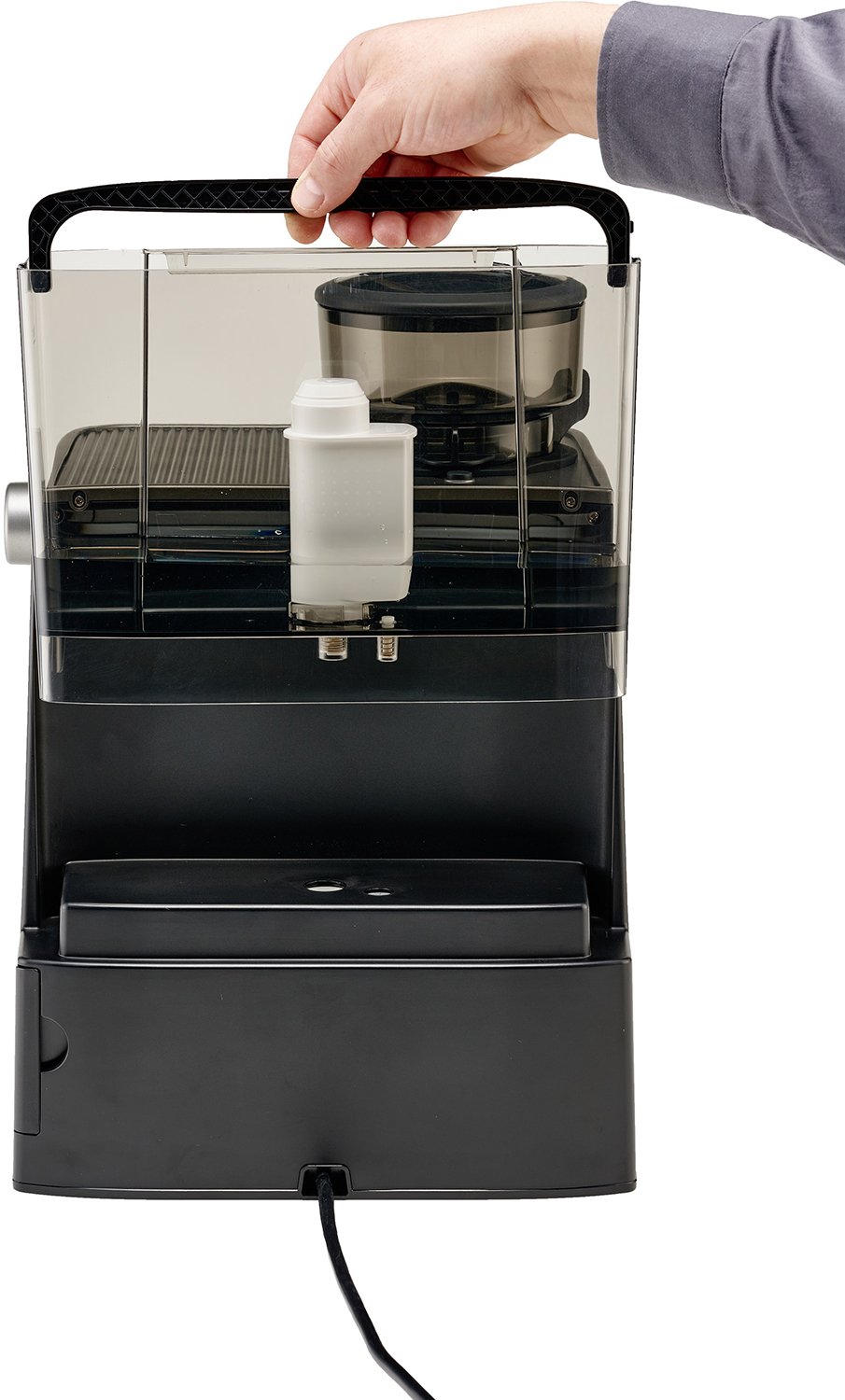 Hand holding a coffee maker with transparent water reservoir.