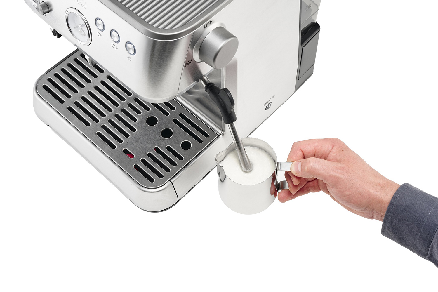 Espresso machine with a person's hand frothing milk into a stainless steel pitcher.