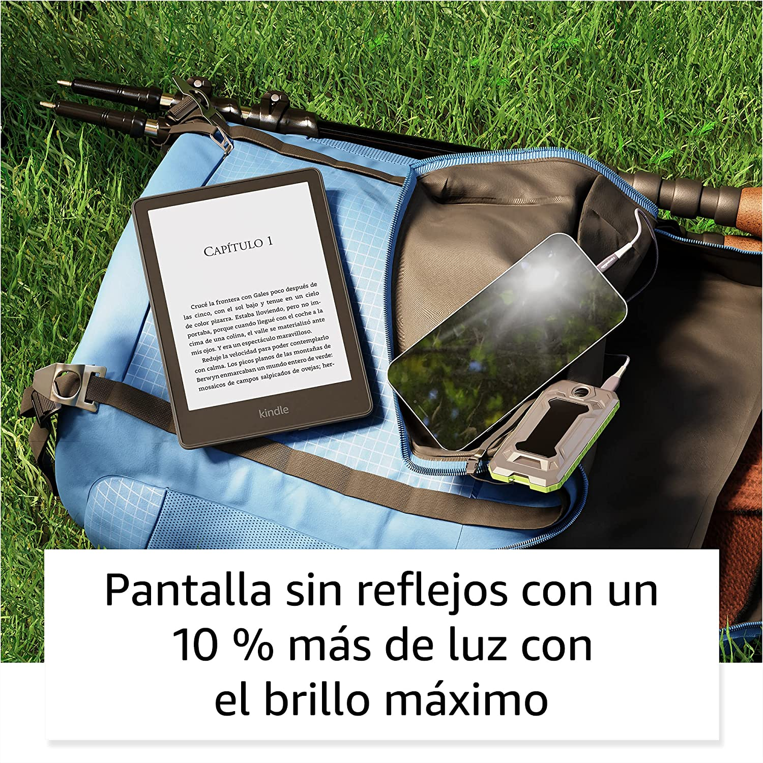 Un Kindle con texto sobre césped con una mochila y un cargador.