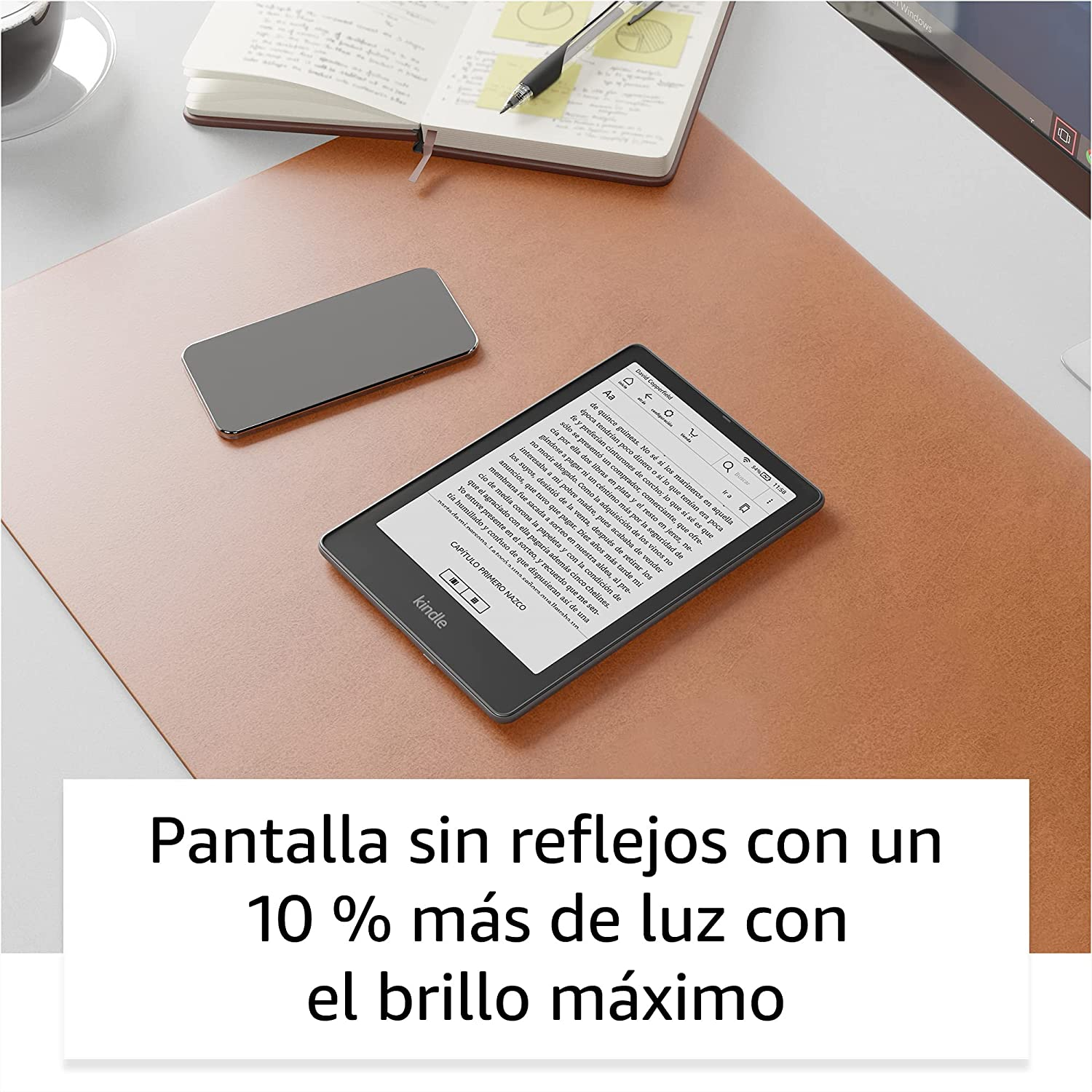 Lector electrónico Kindle en un escritorio con un smartphone. Texto abajo: 'Pantalla con 10% más de luz'.