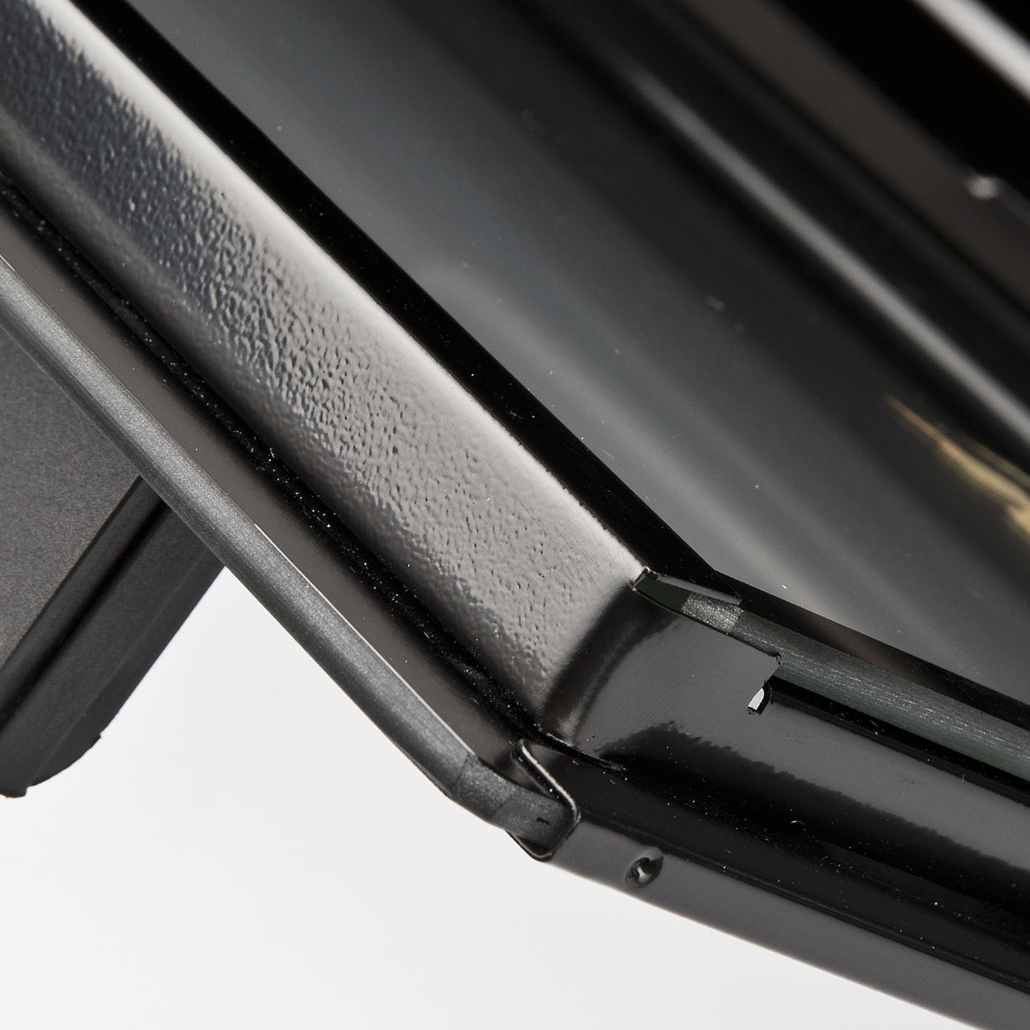 Primo piano di una superficie metallica nera. Mostra un angolo e una linea.