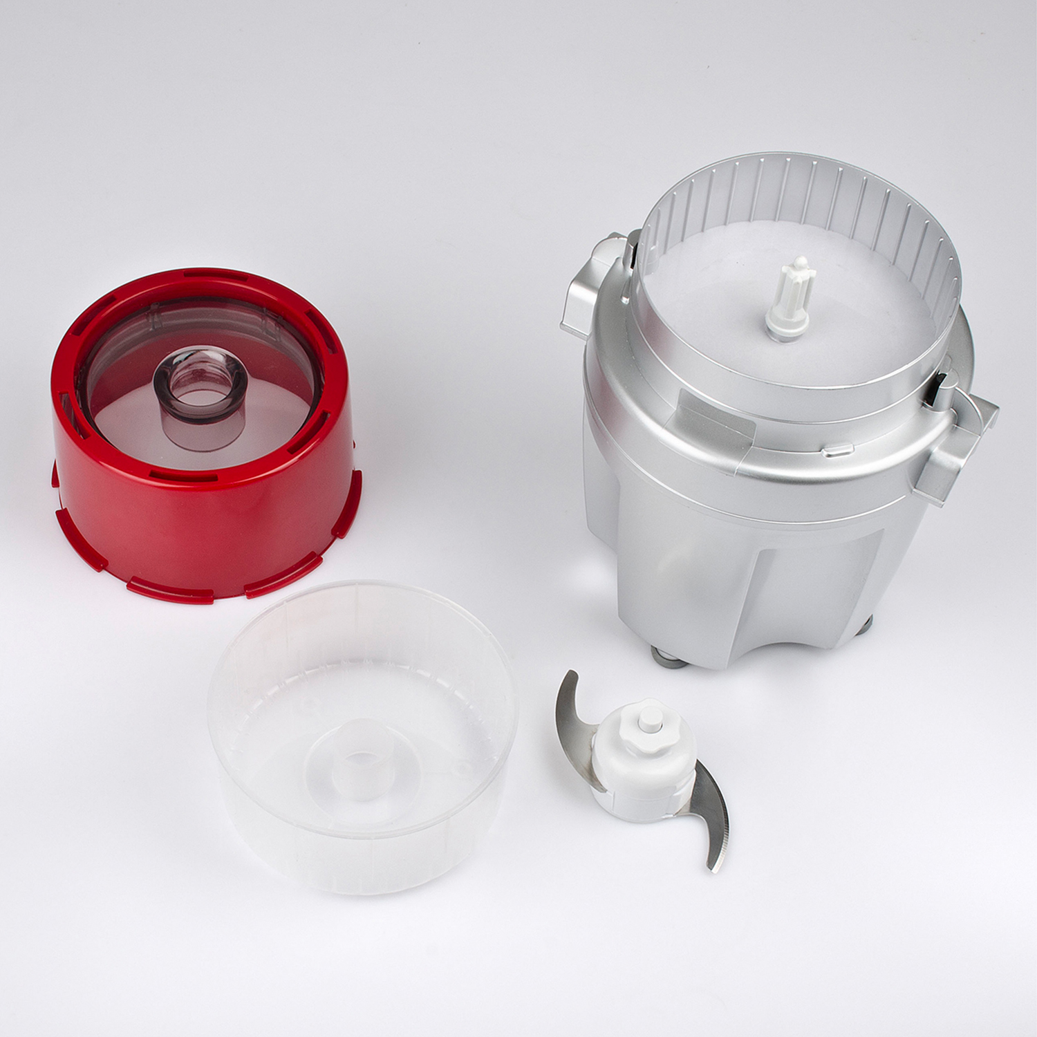 Un robot da cucina con i suoi componenti, tra cui un coperchio rosso, una ciotola trasparente e una lama.