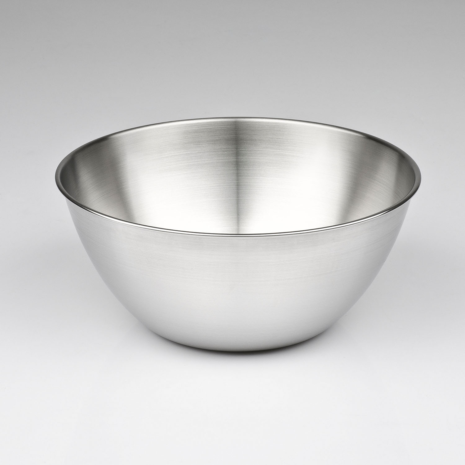 Una ciotola in acciaio inox su una superficie bianca, design semplice e moderno.