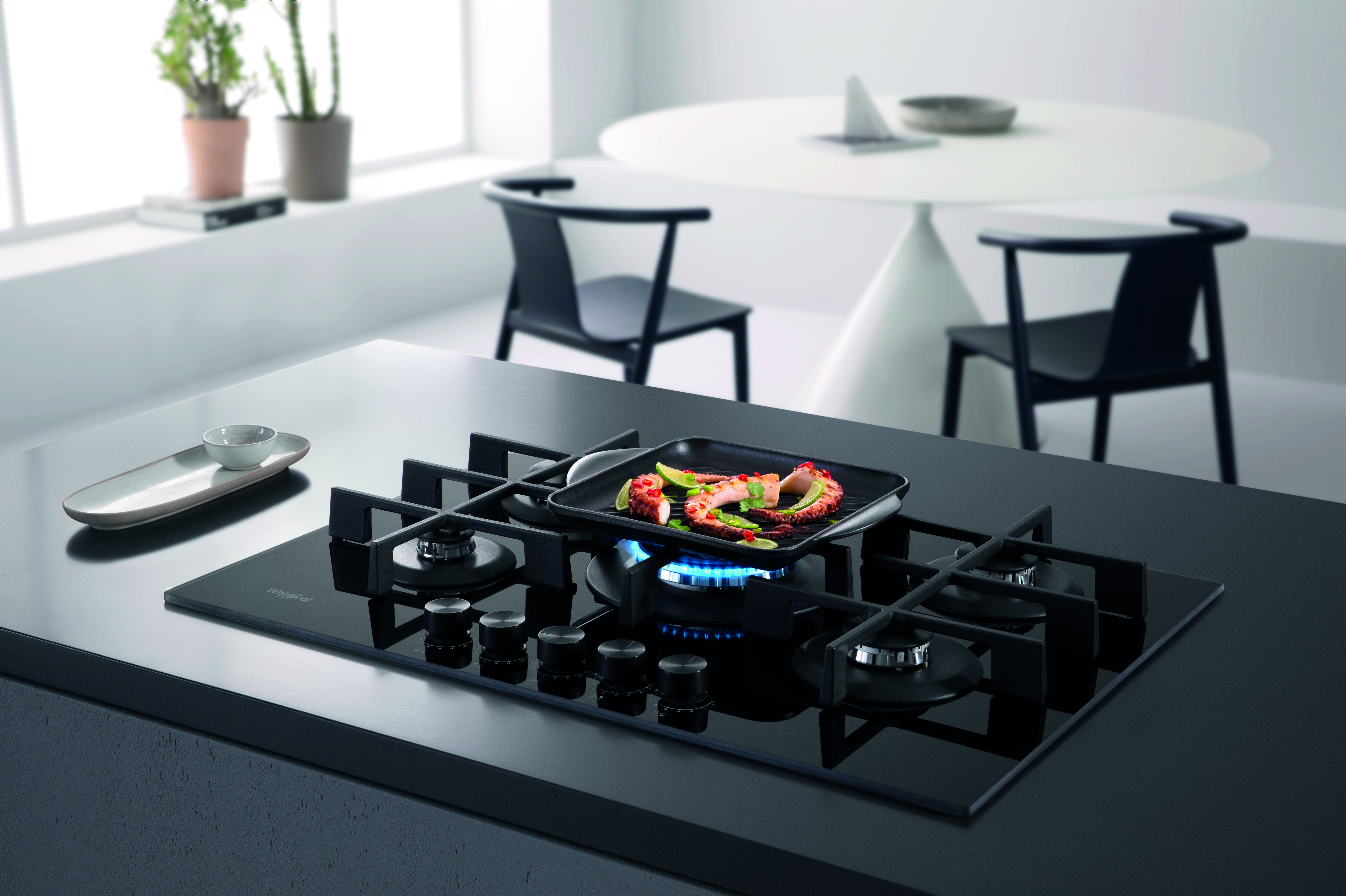 Modern fekete gázfőzőlap grill serpenyővel, étellel.