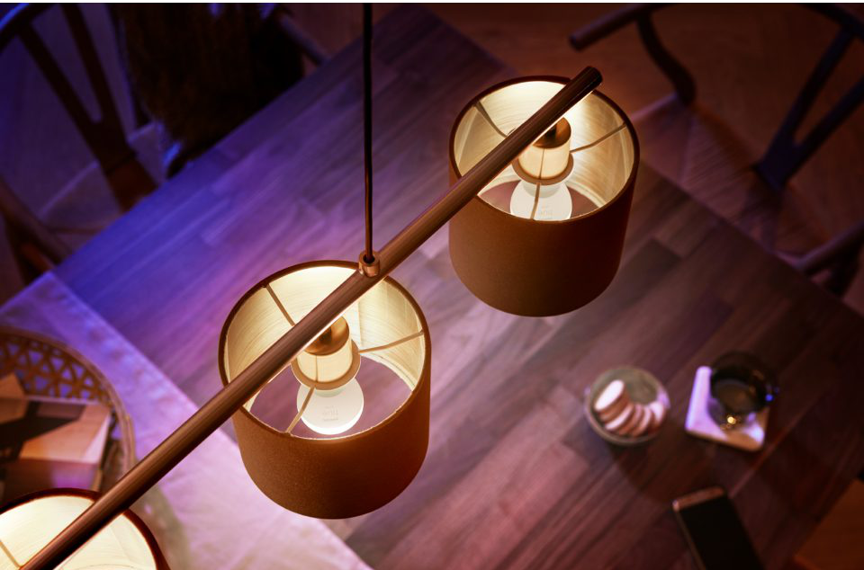Lampes suspendues modernes avec abat-jours cylindriques et ampoules, suspendues au-dessus d'une table.