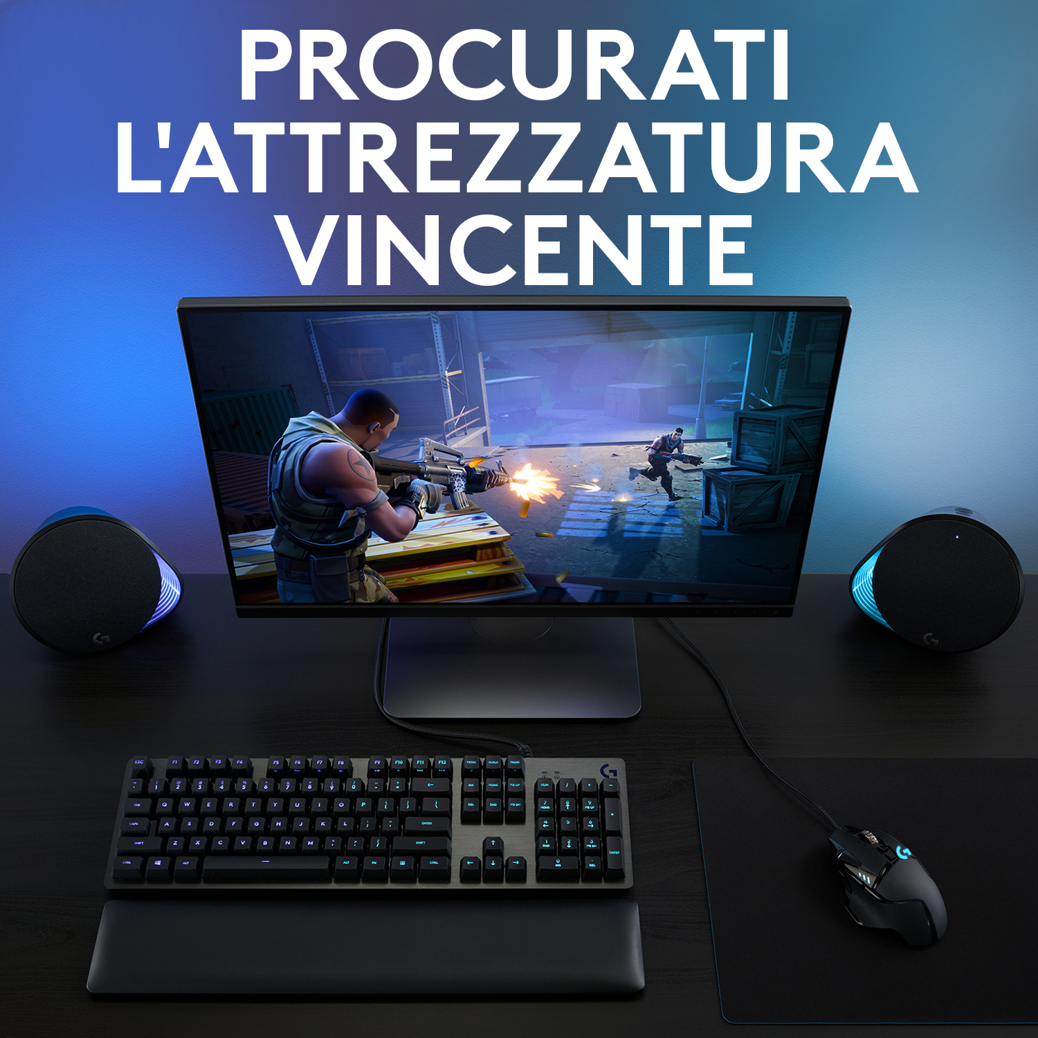 Configurazione gaming: monitor, tastiera, mouse, altoparlanti e scrivania, testo.