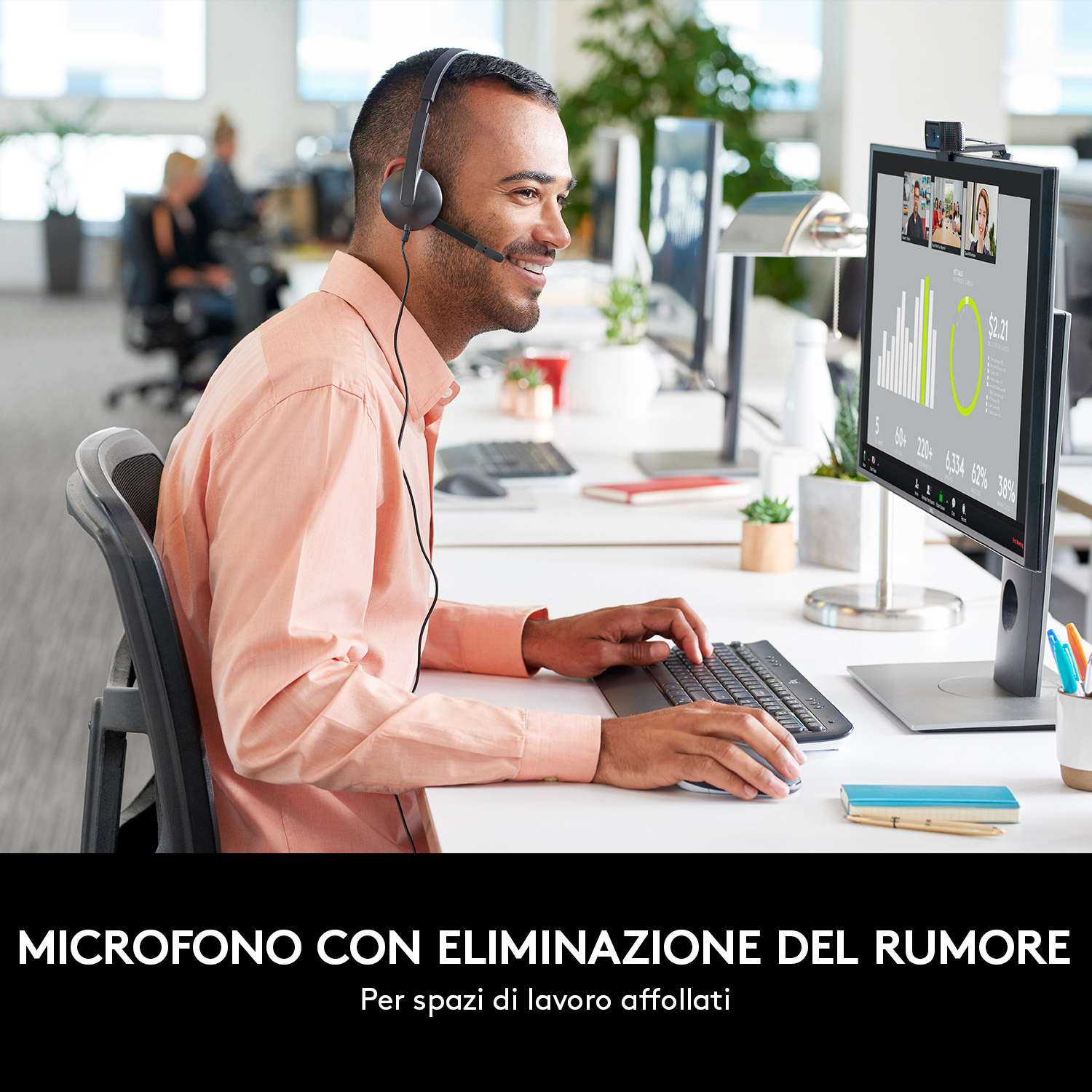Uomo con cuffie in ufficio, al lavoro a una scrivania, schermo del computer con videochiamata.