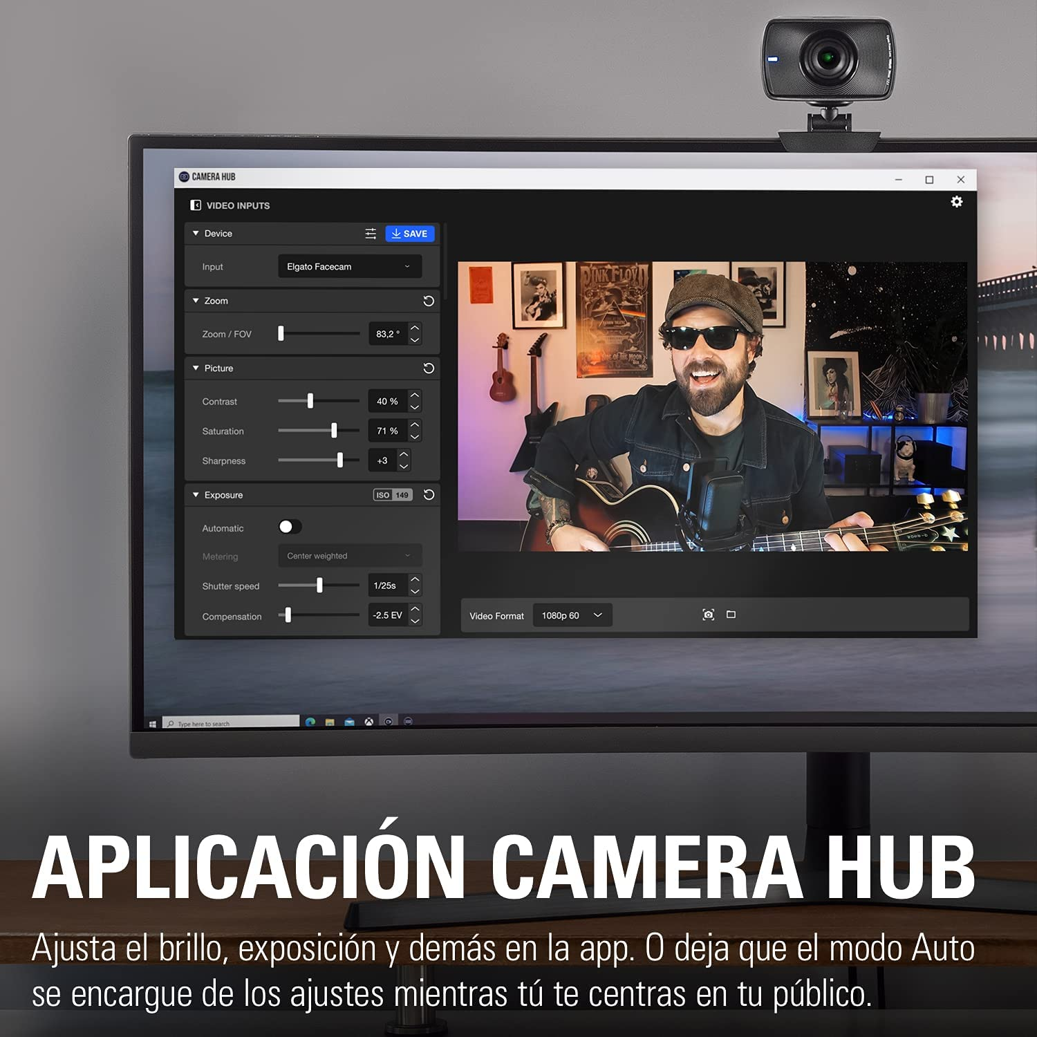 Un hombre tocando la guitarra y utilizando una aplicación de cámara en un monitor.