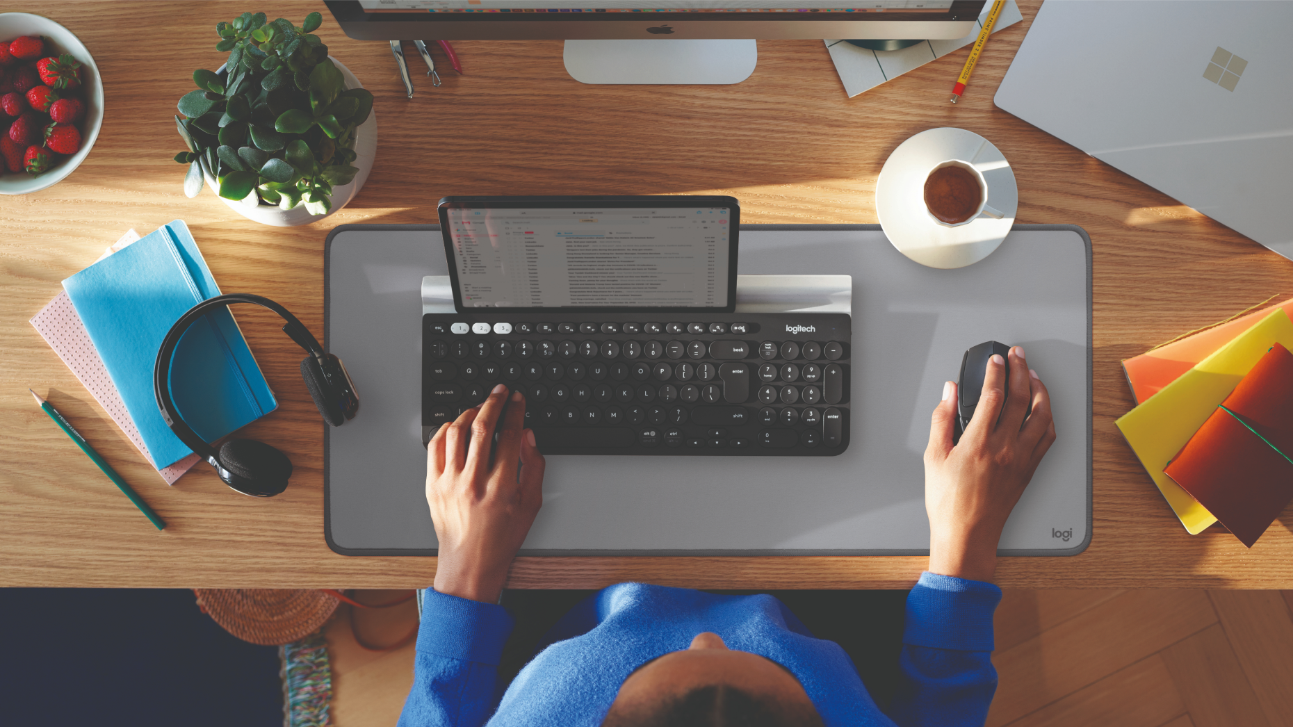 Vue de dessus d'un bureau avec un clavier, une souris, un smartphone et d'autres objets.