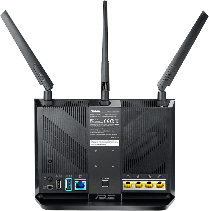Achteraanzicht van een zwarte ASUS-router met drie antennes, poorten en labels.