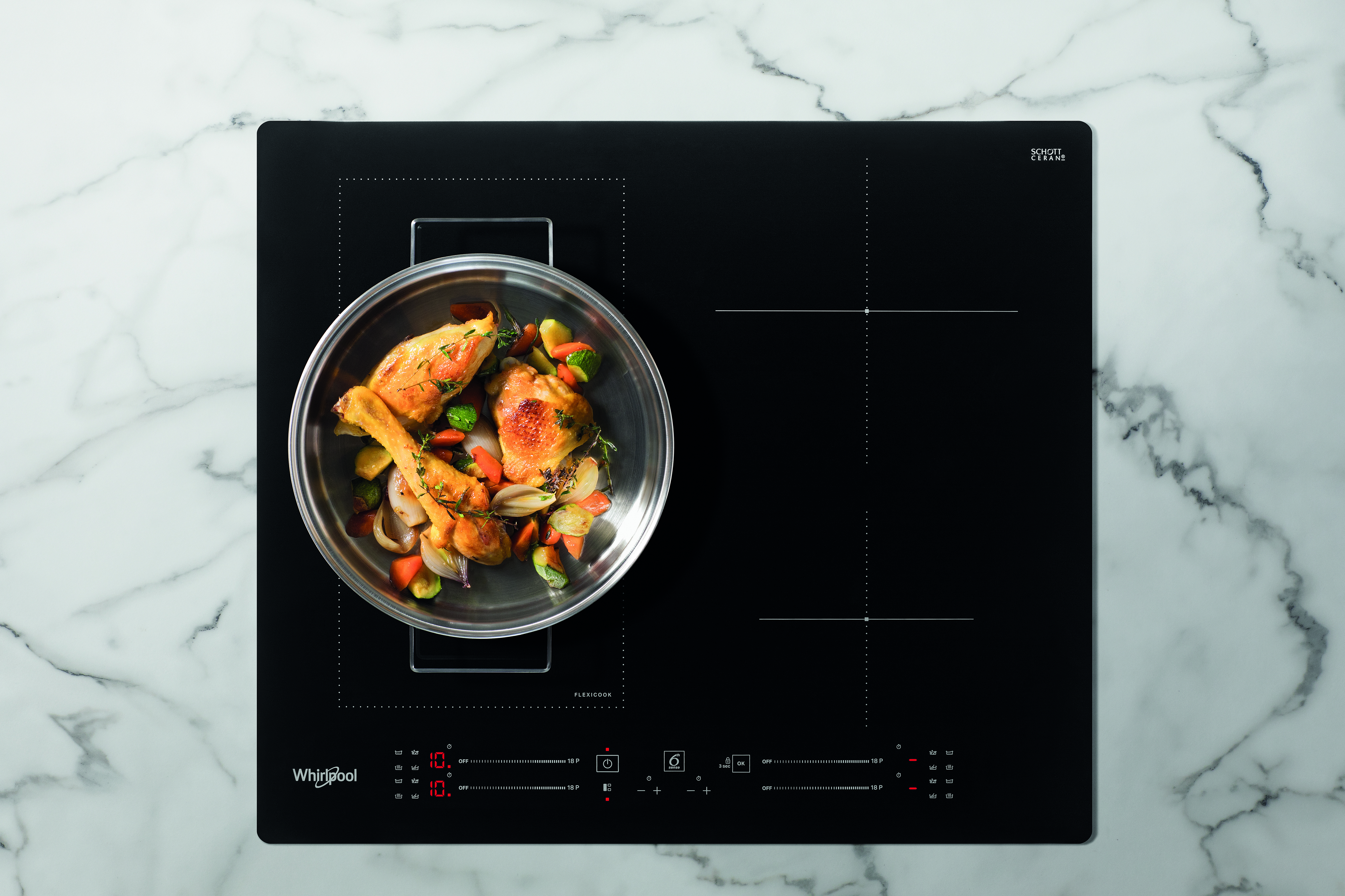 Fekete indukciós főzőlap étellel. Fehér márvány háttér. Whirlpool logó alul.