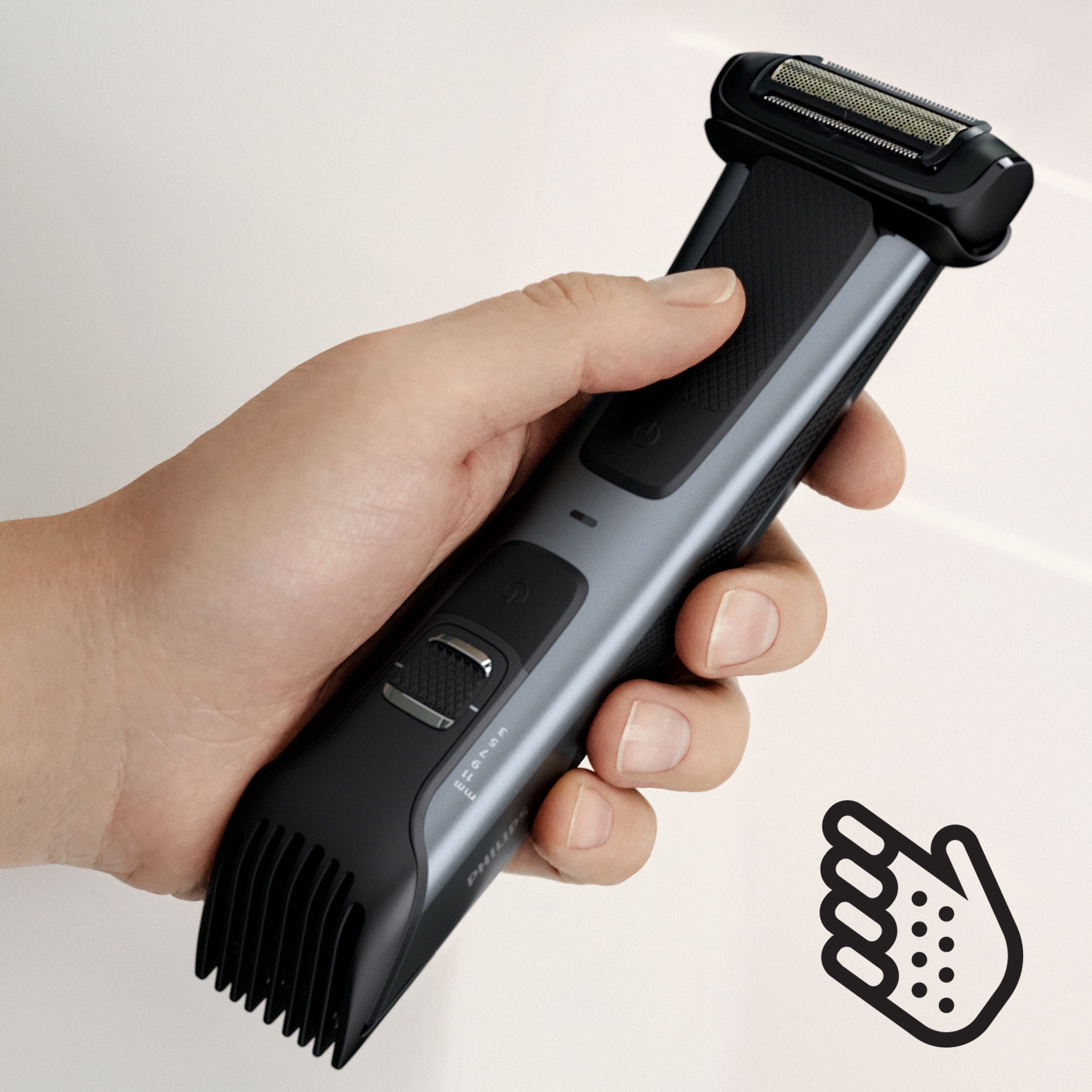 Eine Hand hält einen schwarz-grauen Philips-Trimmer, mit einem handförmigen Symbol.