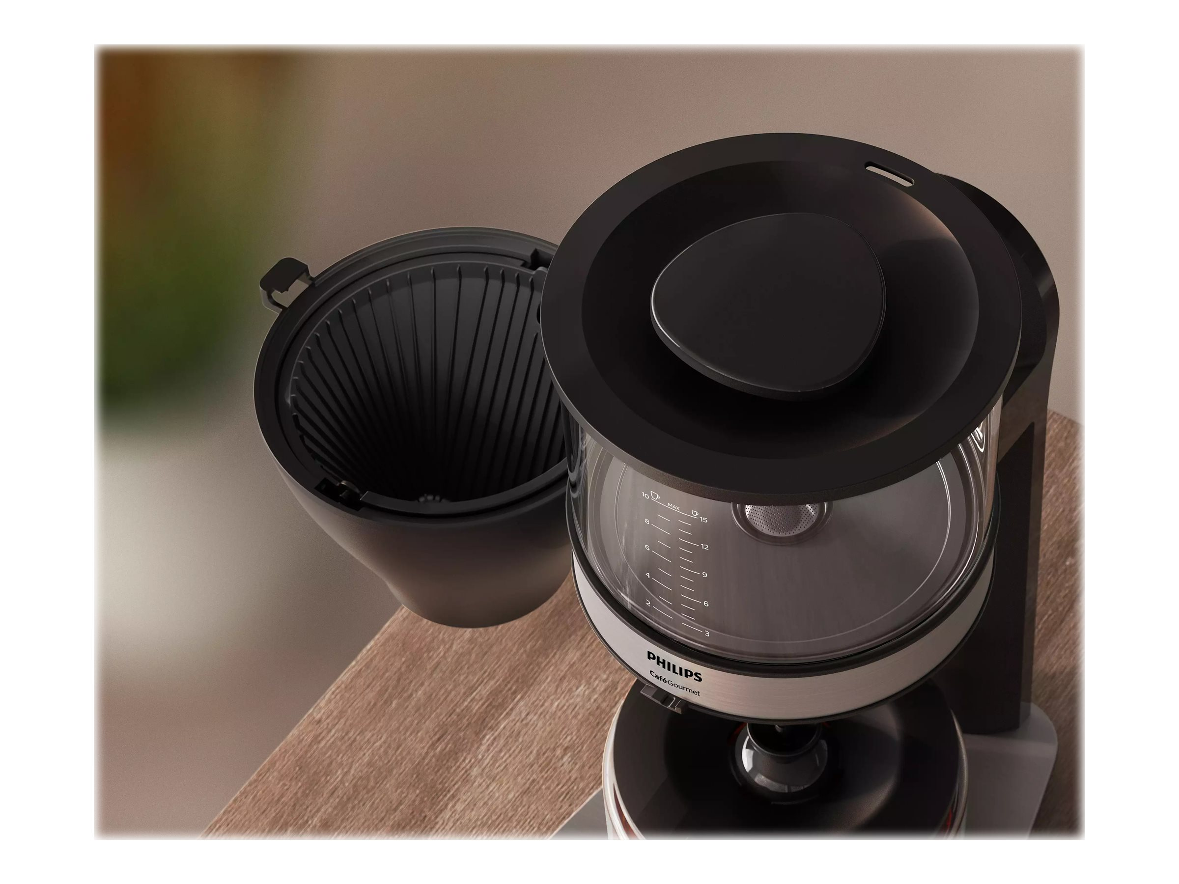 Schwarze Kaffeemaschine mit offenem Deckel, ein Filterkorb ist sichtbar. Die Kaffeemaschine steht auf Holz.