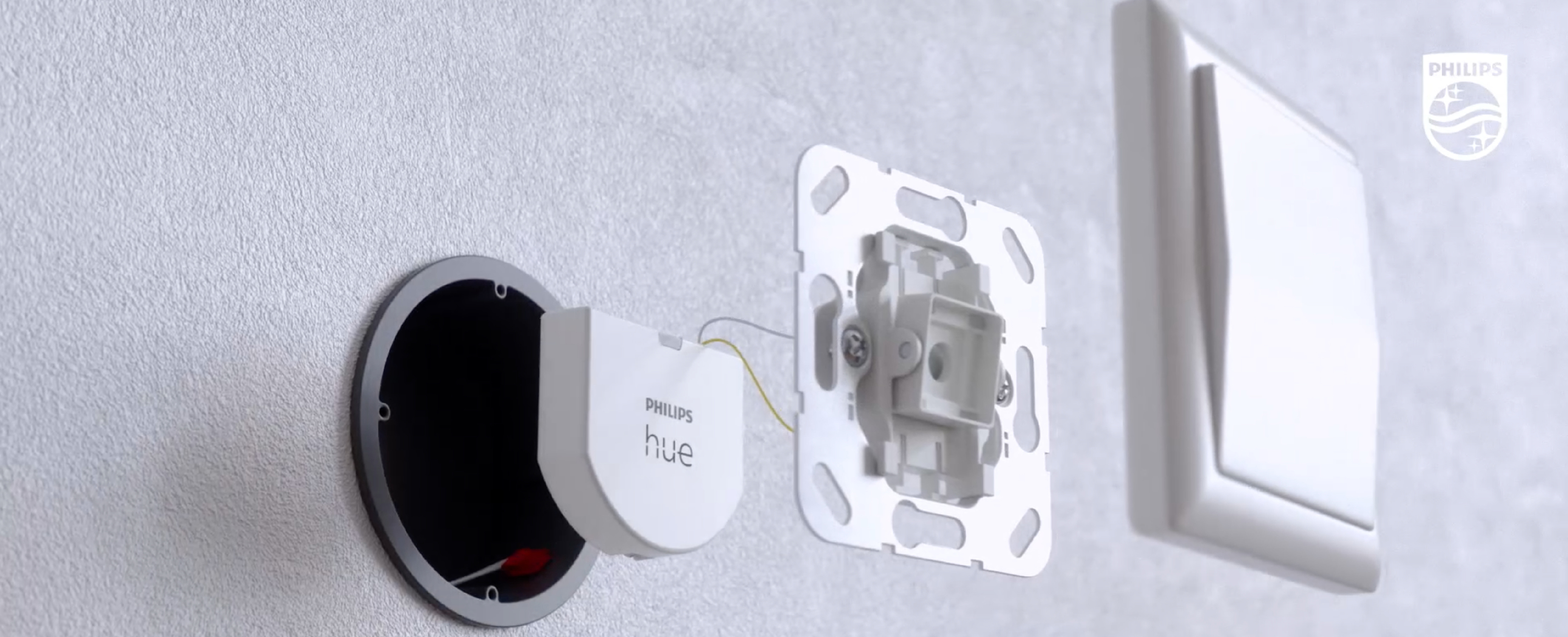 Philips Hue smart lighting components being installed on a wall.