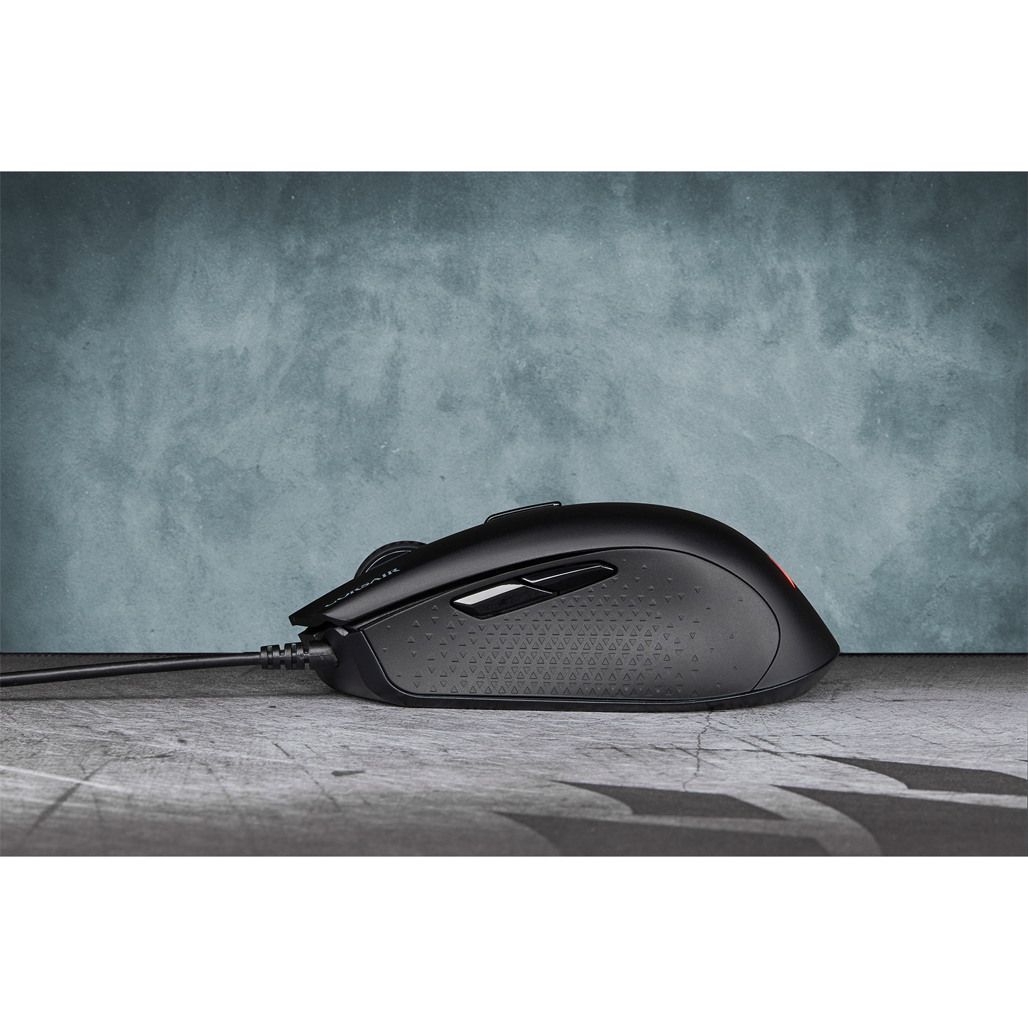 Mouse da gaming nero su superficie strutturata con sfondo blu.