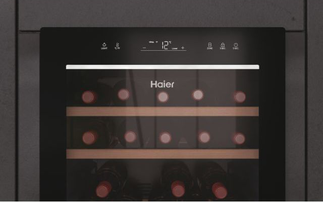 Un frigo per vini con bottiglie, display digitale e mobile nero.