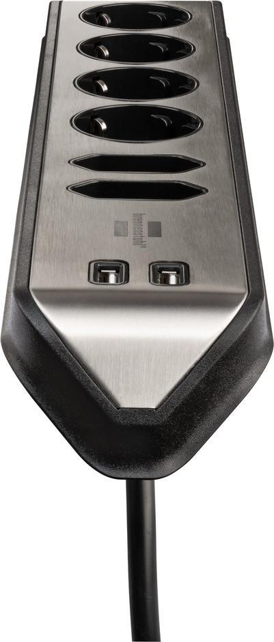 Eine schwarz-silberne Steckdosenleiste mit sechs Steckdosen und zwei USB-Anschlüssen. Schwarzes Kabel.
