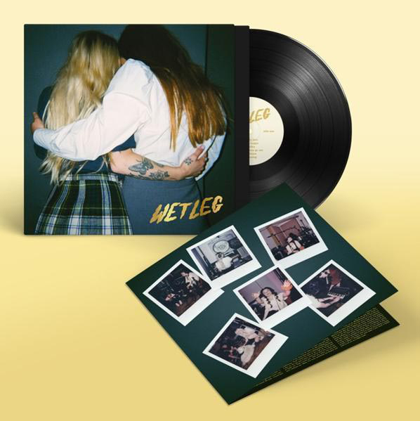 Wet Leg-Albumcover mit zwei sich umarmenden Frauen. Vinyl-Schallplatte rechts, Label sichtbar.