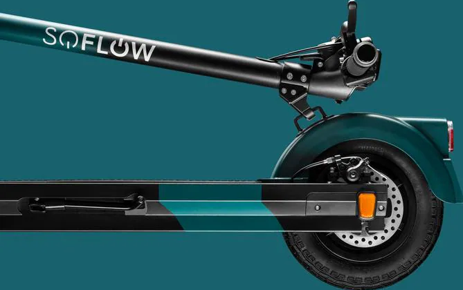 Roller mit SOFLOW-Logo, türkis und schwarz. Rad, Bremse und Kotflügel sind sichtbar. Dunkeltürkisfarbener Hintergrund.