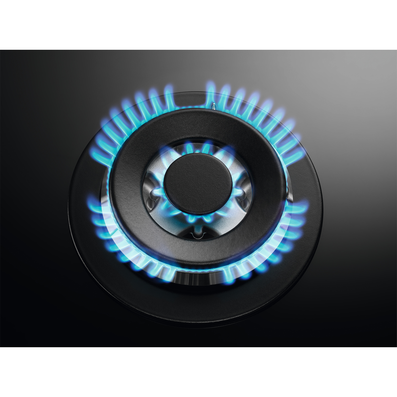 Primo piano di un bruciatore di fornello a gas con fiamme blu.