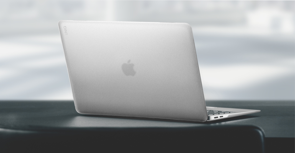 A silver laptop, closed, with the Apple logo visible, sitting on a table.